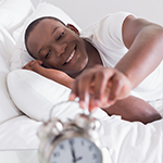 man turning off his alarm clock