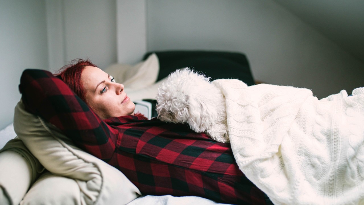 woman laying with her dog looking onward