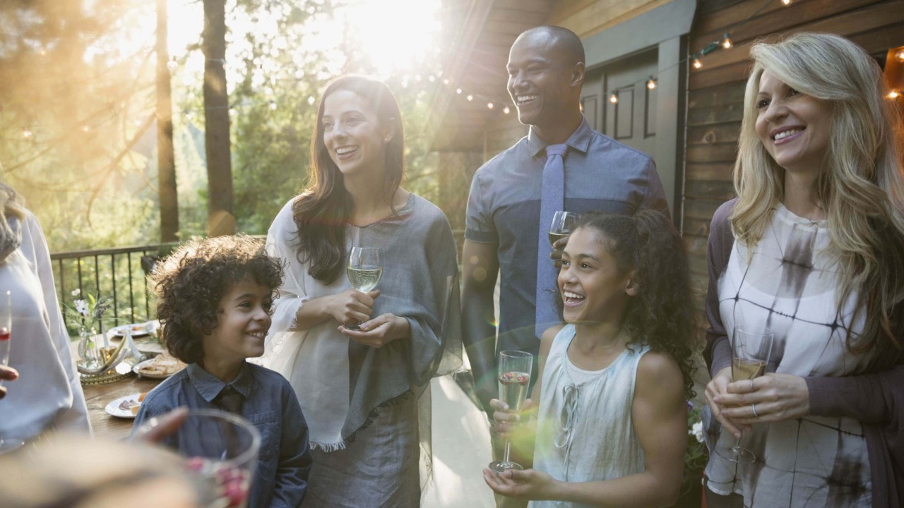 group of people toasting at a gathering outside