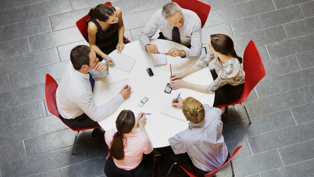 people sitting around a table in a work meeting