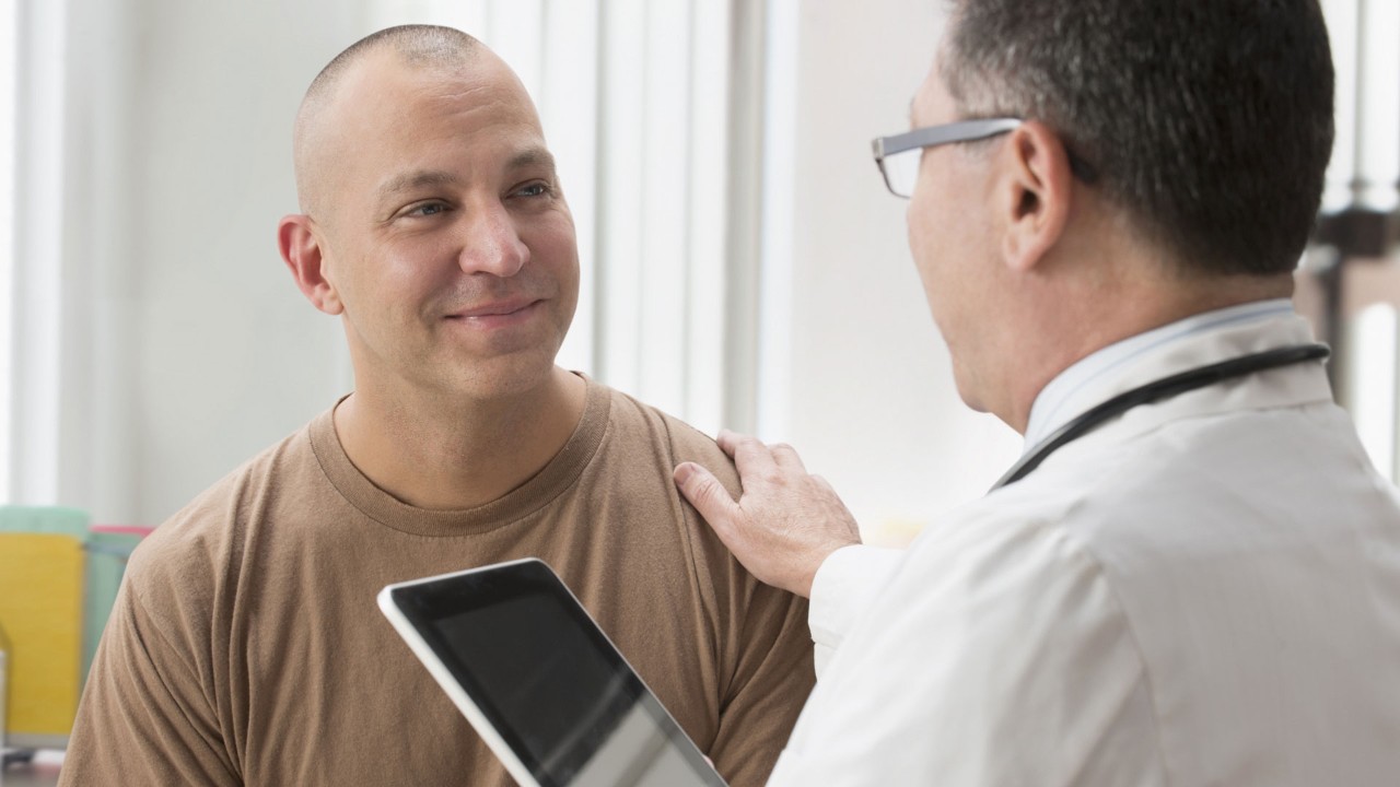 doctor putting his hand on a patient's shoulder