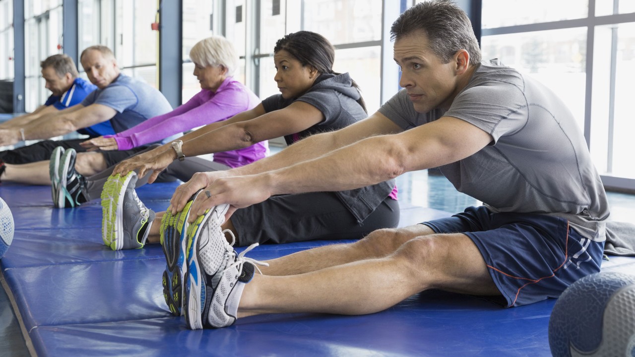 group of people stretching at the gym