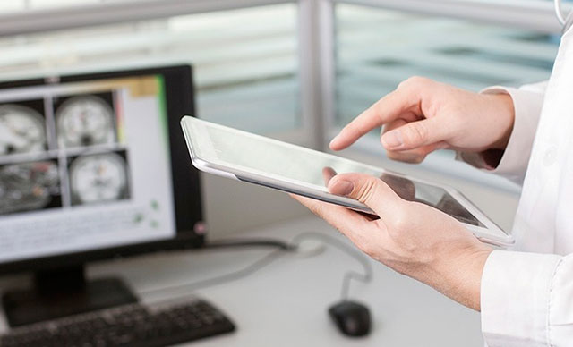 close up of doctor's hands clicking an ipad