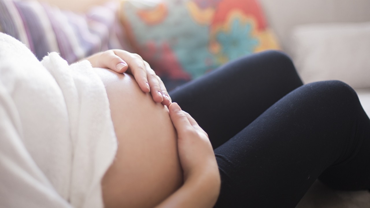 close up of pregnant woman holding her stomach