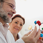 man and woman holding fake molecules