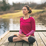 woman meditating in the woods