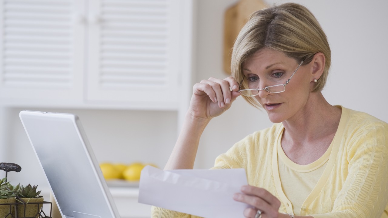 woman looking at a piece of paper with glasses